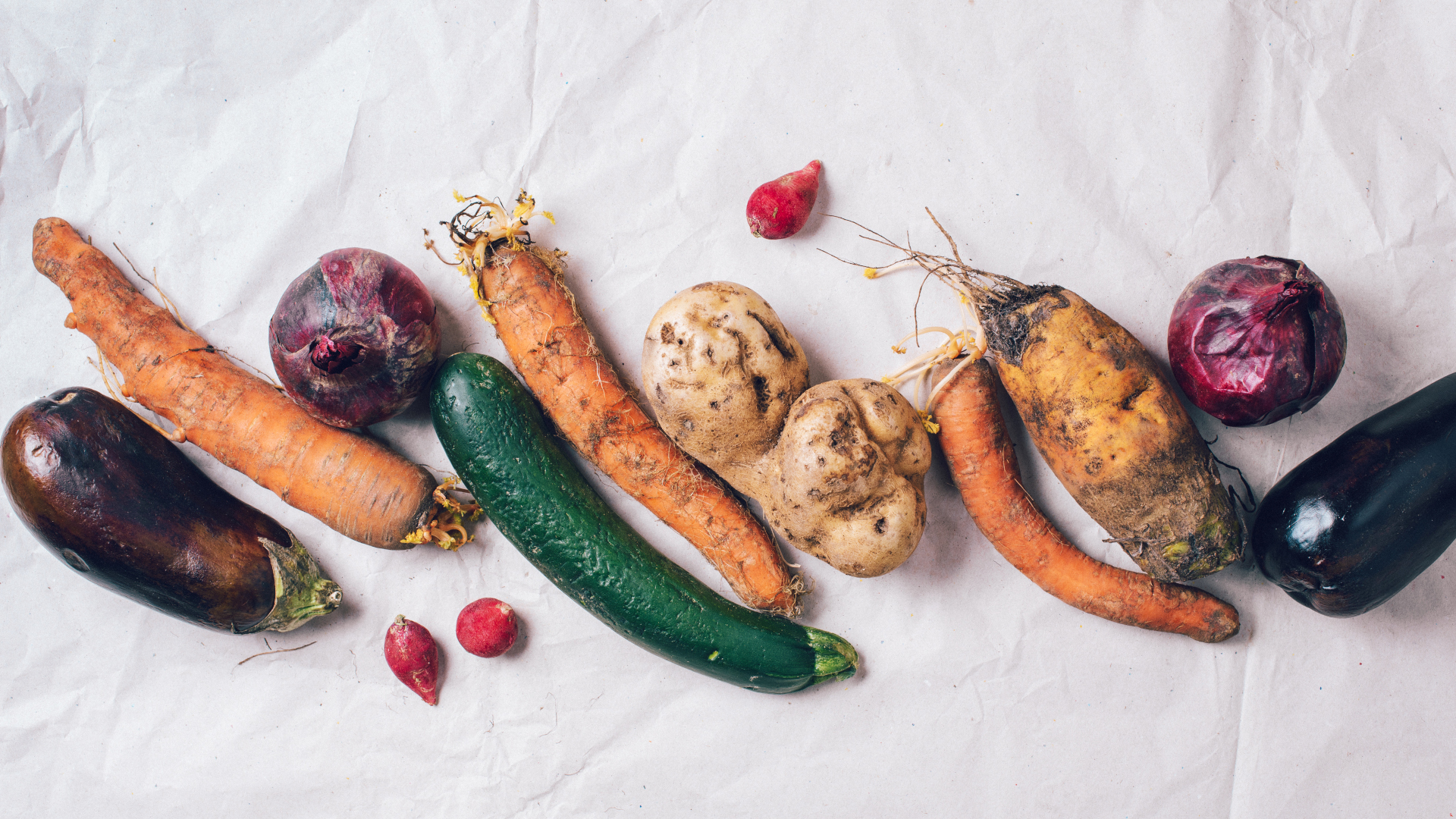 Verrottetes Gem&uuml;se liegt auf wei&szlig;em Papier